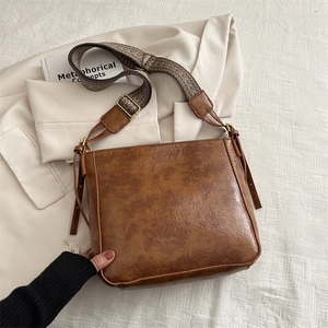 Retro brown PU leather bucket bag with wide woven strap and vintage textured finish
