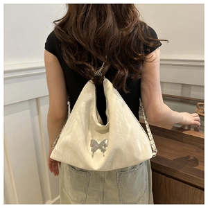 Détail du sac hobo blanc en cuir froissé brillant avec boucle papillon argentée élégante