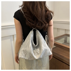 Sac hobo argenté avec effet froissé métallisé et un pendentif papillon très élégant