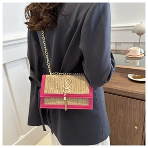 Détail du sac bandoulière en paille tressée avec bordure en cuir rose et chaîne