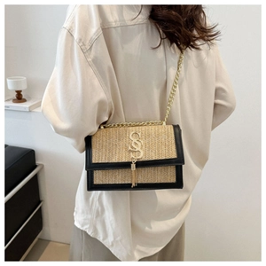 Détail du sac bandoulière en paille tressée avec pendentif S doré et chaîne chic