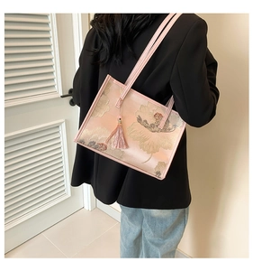 Dettaglio della borsa tote rosa ricamata con motivi floreali e nappa di seta