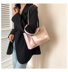 Detailed shot of pink floral tote bag with fringe charm and slim shoulder straps
