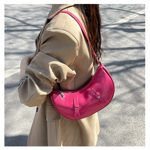 Detail of pink crescent bag showing glossy patent leather and silver metal buckles