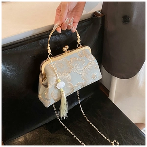 Detail of light blue floral embroidery on Chinese style bag with silk tassel and metal handle
