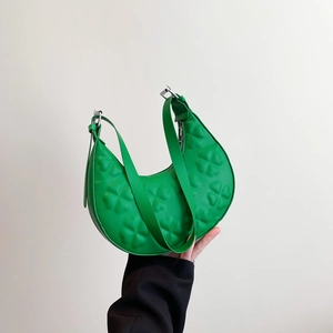 Green crescent shoulder bag with embossed clover pattern and adjustable strap