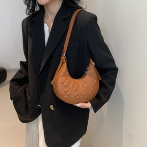 Brown half-moon shoulder bag with clover embossed texture and adjustable strap