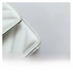 Macro detail of white faux leather small square bag with premium V-shaped quilting stitch