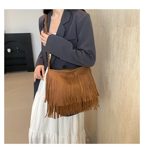Detail of brown fringe crossbody bag featuring woven straps and layered tassels