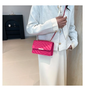 Close-up of rose pink quilted crossbody bag with gold chain strap and metal lock detail