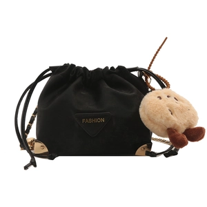 Black drawstring bucket bag with gold chain strap and plush pendant on white background