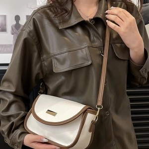 Minimalistische beige-braune Satteltasche getragen von einem Modell in braunem Hemd