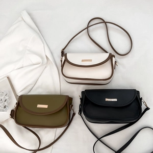 Drei minimalistische Umhängetaschen in Beige, Oliv und Schwarz mit Metallplakette
