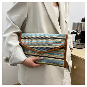 Detail of woven striped envelope clutch bag with leather trim and vibrant summer colors