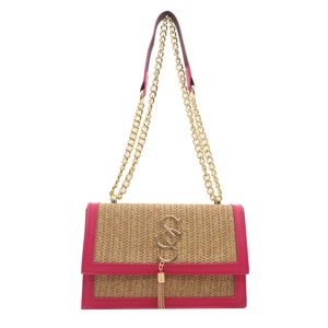 Woven straw crossbody bag with pink leather trim and gold chain strap in a studio shot