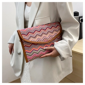 Detail of colorful zigzag woven clutch featuring vibrant patterns and brown trim