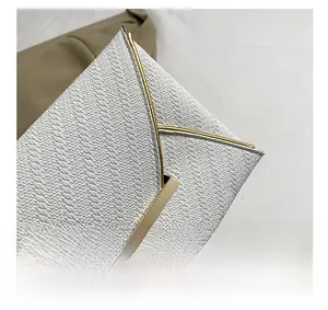 Vue détaillée de la pochette enveloppe blanche avec texture tissée et liseré doré