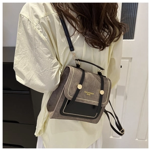 Detail of taupe matte finish backpack with contrast black trim and gold hardware