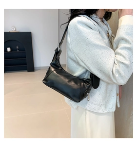 Detailansicht der schwarzen Hobo-Tasche aus Glattleder mit verstellbarem Gurt und Silberzipper