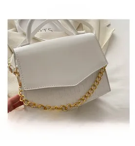 Detail view of white crocodile pattern crossbody bag with thick gold chain decoration