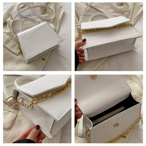 Detail view of white crocodile pattern bag with gold chain and interior storage