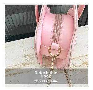 Détail du sac papillon rose montrant le crochet doré amovible et la couture fine