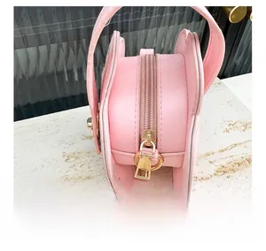 Détails de la fermeture éclair rose fluide et des finitions dorées du sac à main papillon