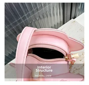 Détail du petit sac rose montrant la fermeture éclair supérieure et la bandoulière dorée