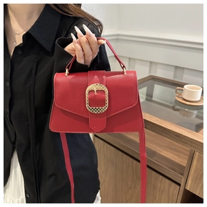 Close-up of red lychee textured leather handbag with a large gold rectangular buckle