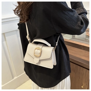 Detail of off-white lychee leather crossbody bag with golden woven texture metal clasp