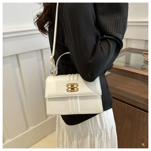 Détail du sac à rabat en cuir matelassé blanc avec fermoir en métal doré et bandoulière chic