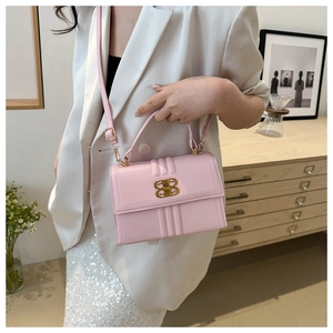 Détail du sac à main en similicuir rose avec matelassage vertical et boucle dorée en B