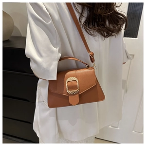 Macro detail of brown pebble grain leather handbag with gold textured square buckle