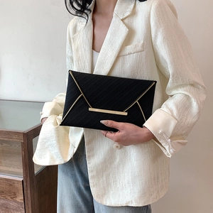 Pochette enveloppe noire chic avec détails dorés et texture tissée fine pour femme
