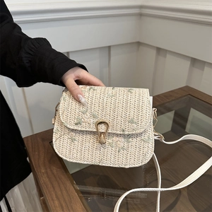 Straw woven saddle bag with floral embroidery and golden metal clasp for summer