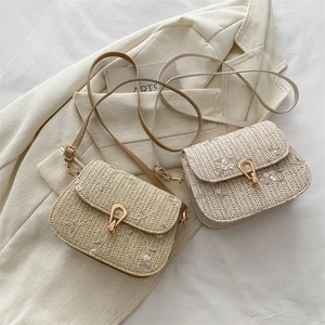 Floral embroidered straw saddle bag with gold metal clasp and adjustable shoulder strap