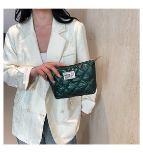 Gros plan d'un mini sac matelassé vert foncé avec finition brillante et étiquette mode