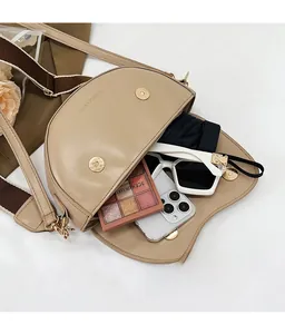 Interior view of beige saddle bag showing spacious storage for makeup and accessories