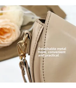 Detail of premium beige saddle bag with detachable golden hook and neat stitching