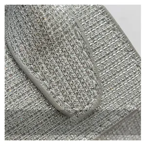 Macro view of silver sequin fabric and high-density stitching on the mini square handbag