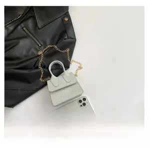 Detail view of mini silver glitter crossbody bag with elegant gold chain strap