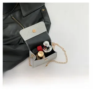 Detail showing the inner capacity of the grey woven chain bag with gold hardware