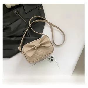 Détails du sac bandoulière beige matelassé avec grand nœud et texture cuir élégante