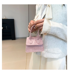 Detailed view of mini pink glitter handbag with gold chain strap and dual top handles