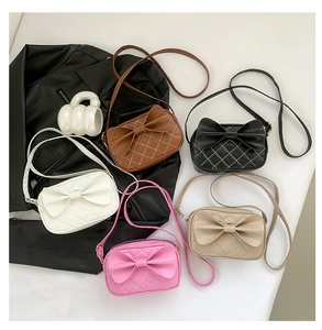 Gros plan de cinq options de couleurs du sac à bandoulière matelassé avec nœud chic en similicuir