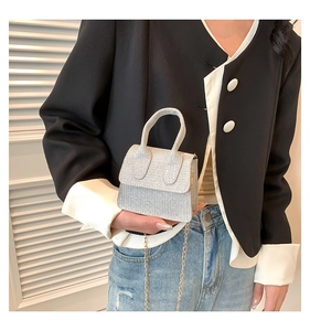 Close-up of mini silver rhinestone handbag with elegant metal chain and flap cover