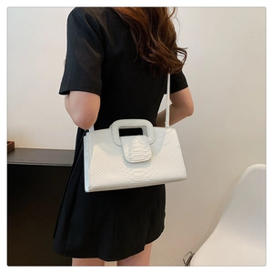 Detailed view of white crocodile pattern crossbody bag with square cutout handle