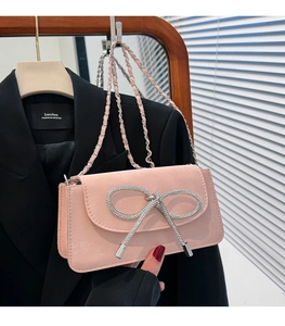 Detailansicht der rosa Wildleder-Umhängetasche mit funkelnder Strass-Schleifenschnalle