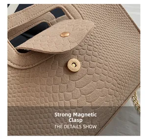 Close-up of khaki faux crocodile skin handbag featuring a strong golden magnetic buckle