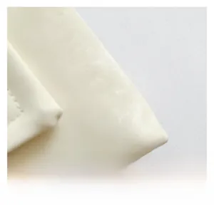 Close-up of premium cream faux leather texture with precise stitching on shoulder bag